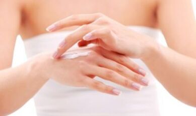 dekle si nanaša mazilo na roko